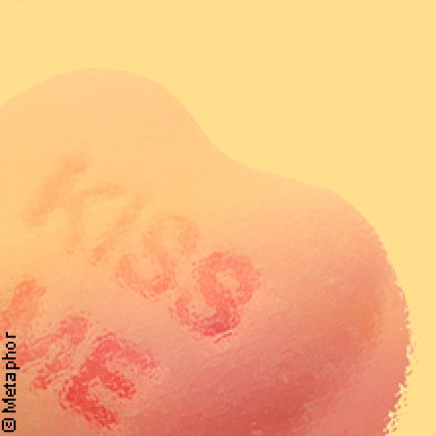 Ein herzförmiges Bonbon mit der Aufschrift „Kiss Me“.
