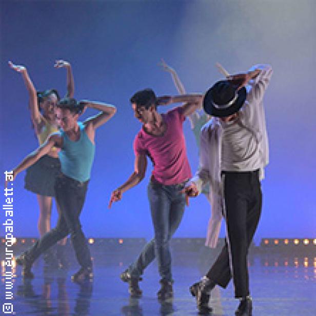 Eine Gruppe von Tänzern führt eine Choreografie auf einer Bühne auf.