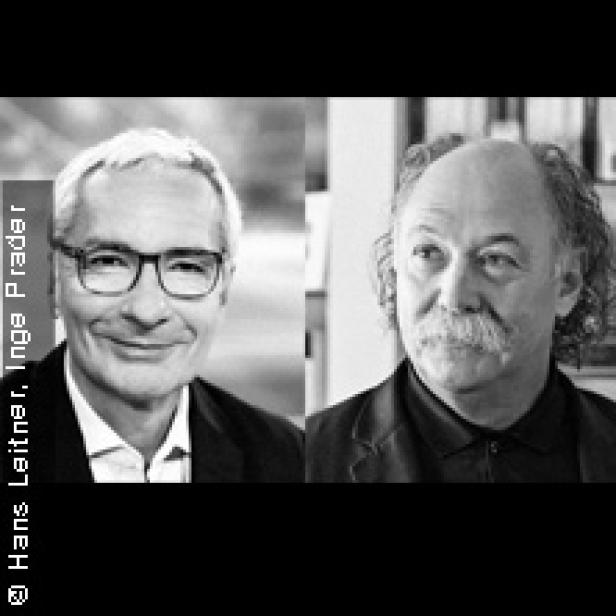 Schwarz-Weiß-Porträt von zwei Männern, einer mit Brille und der andere mit Schnurrbart.