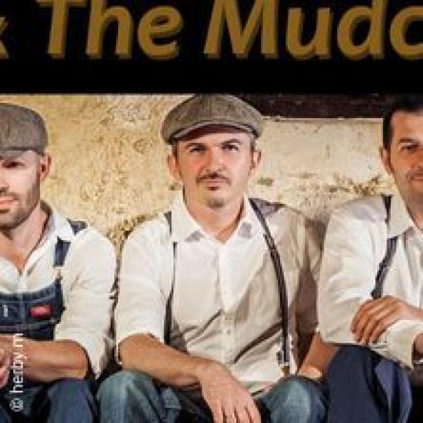 Drei Männer mit Schiebermützen und Hosenträgern sitzen nebeneinander.